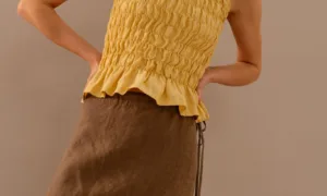 Close-up of yellow linen smocked top showing gathered texture and fitted silhouette