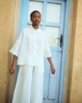 model is wearing oversized white linen shirt and white linen culottes