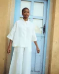 model is wearing oversized white linen shirt and white linen culottes
