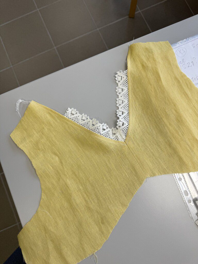 Detail of a linen garment with lace trim during the made to order process