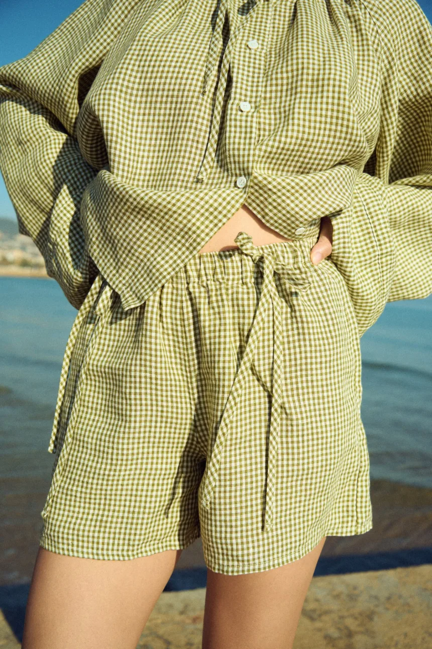 Green mini gingham linen shorts with elasticated waistband and decorative ties, paired with a matching top
