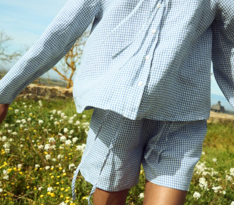 Blue gingham linen top with clean shell button front and relaxed sleeves, paired with coordinating shorts