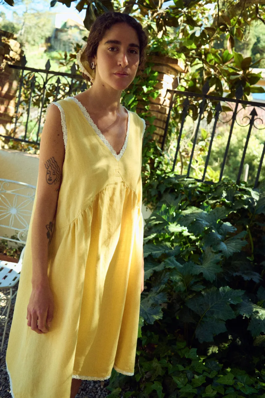 Butter yellow linen sleeveless midi dress with lace-trim V-neck, armholes, and hem, and a gently gathered waist