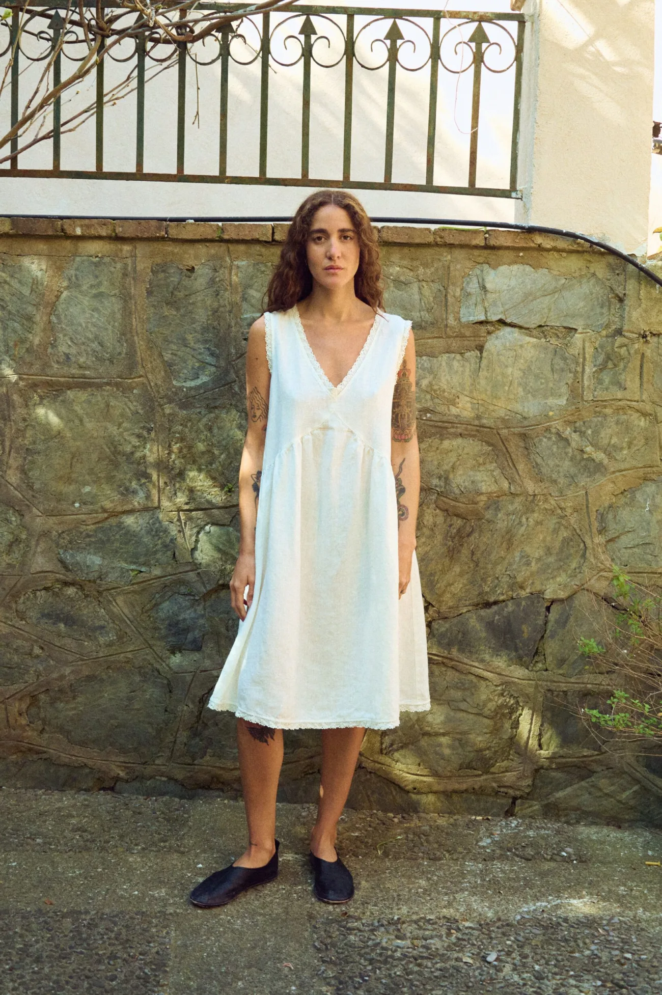 Front view of milky white linen sleeveless midi dress with V-neck, lace-trim neckline and hem, and softly gathered waist