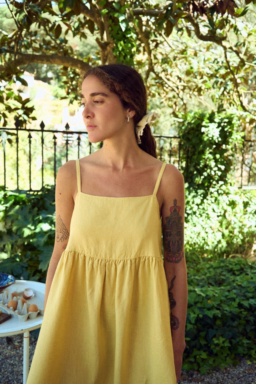 Yellow linen dress with thin straps and gathered midi skirt