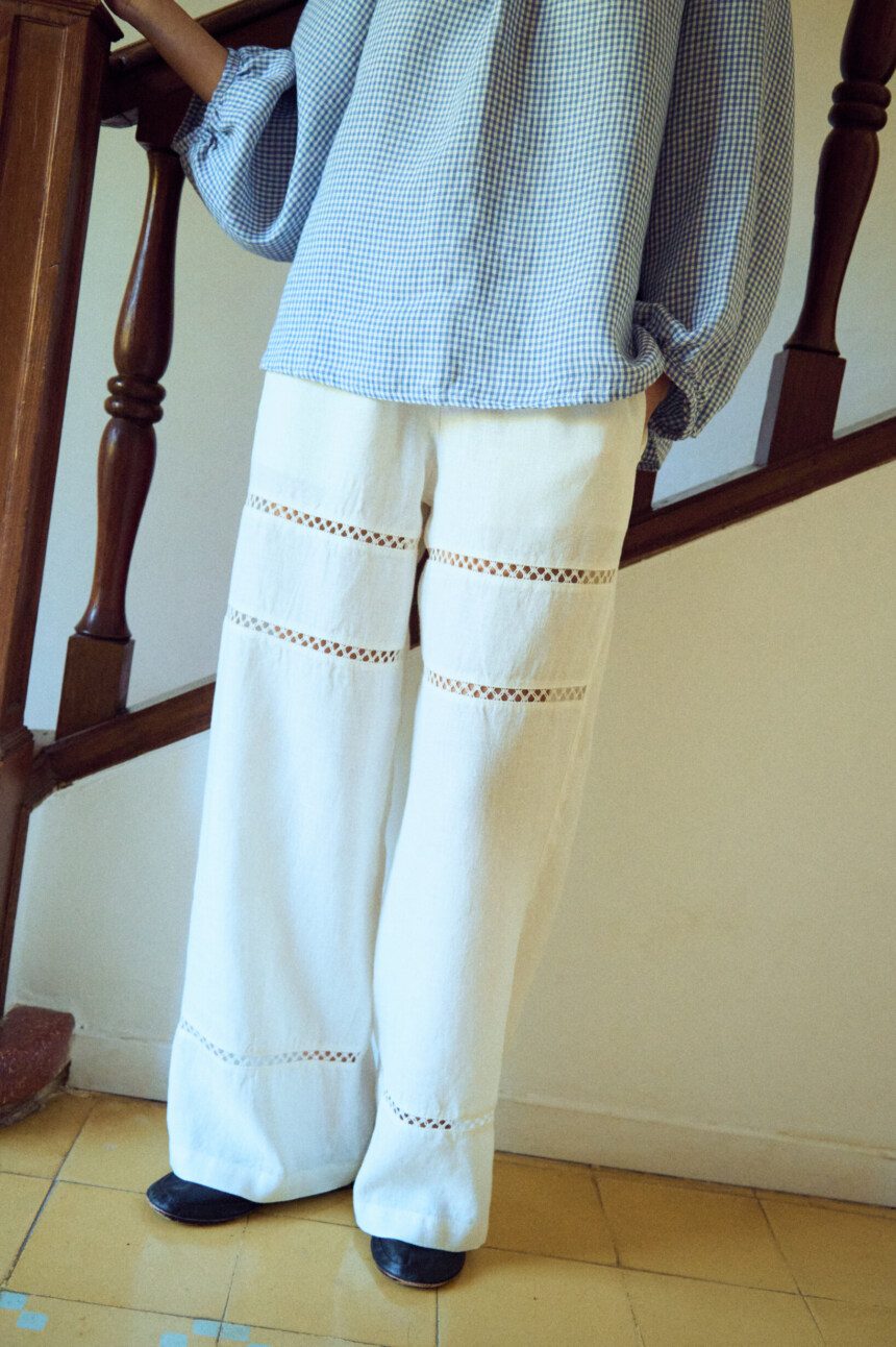 woman is wearing white lace pants in white linen