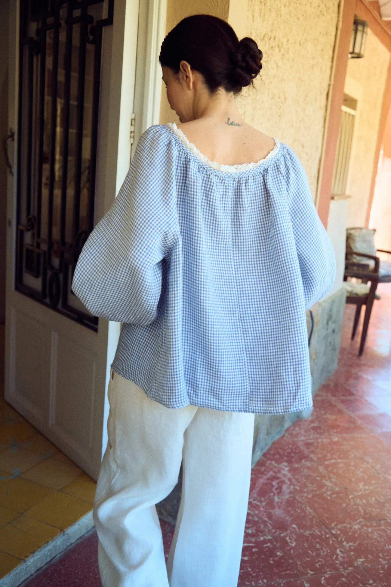 back view of oversized blue gingham blouse with lace neckline