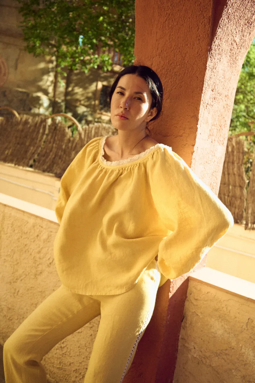 woman is wearing oversized linen blouse in butter yellow color