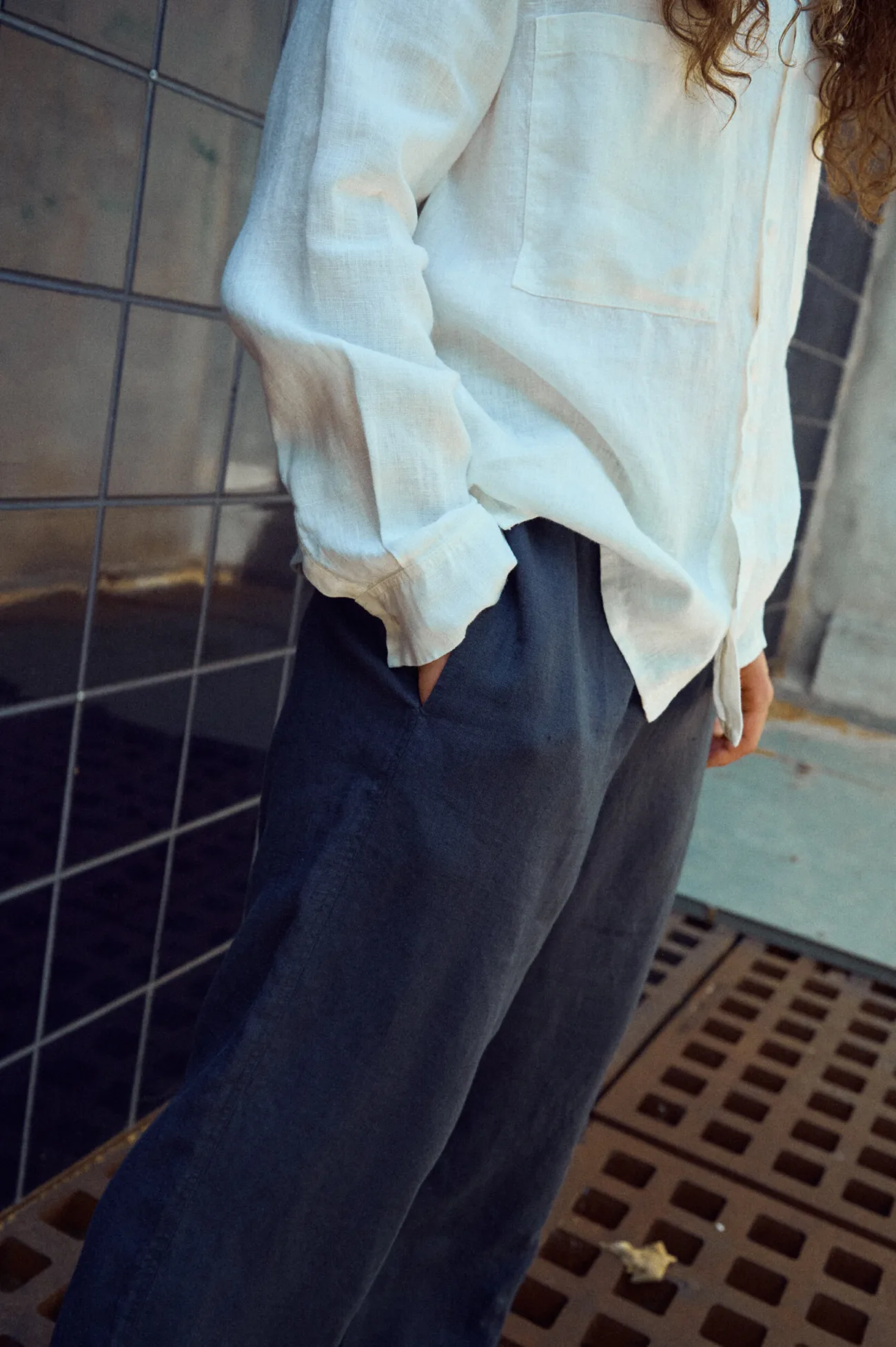 Men’s graphite grey linen trousers with a relaxed wide-leg fit and side pockets, styled with a white linen shirt