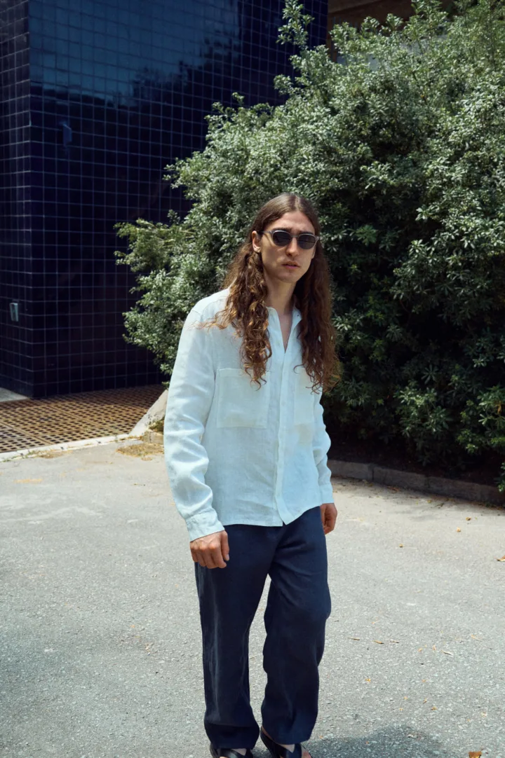 Men’s graphite grey linen trousers cut in an easy, loose silhouette, paired with a milky white linen shirt