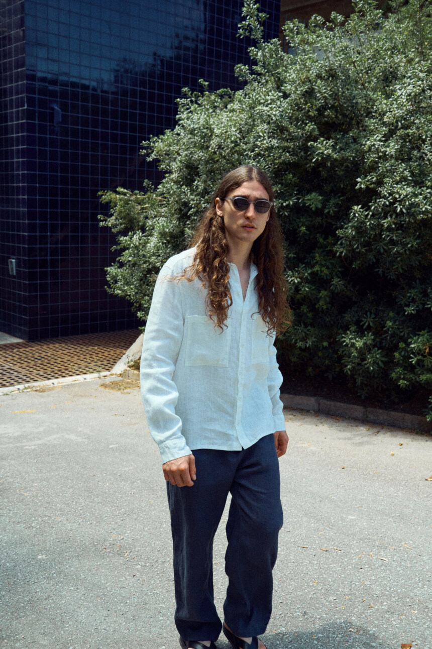 Men’s graphite grey linen trousers cut in an easy, loose silhouette, paired with a milky white linen shirt