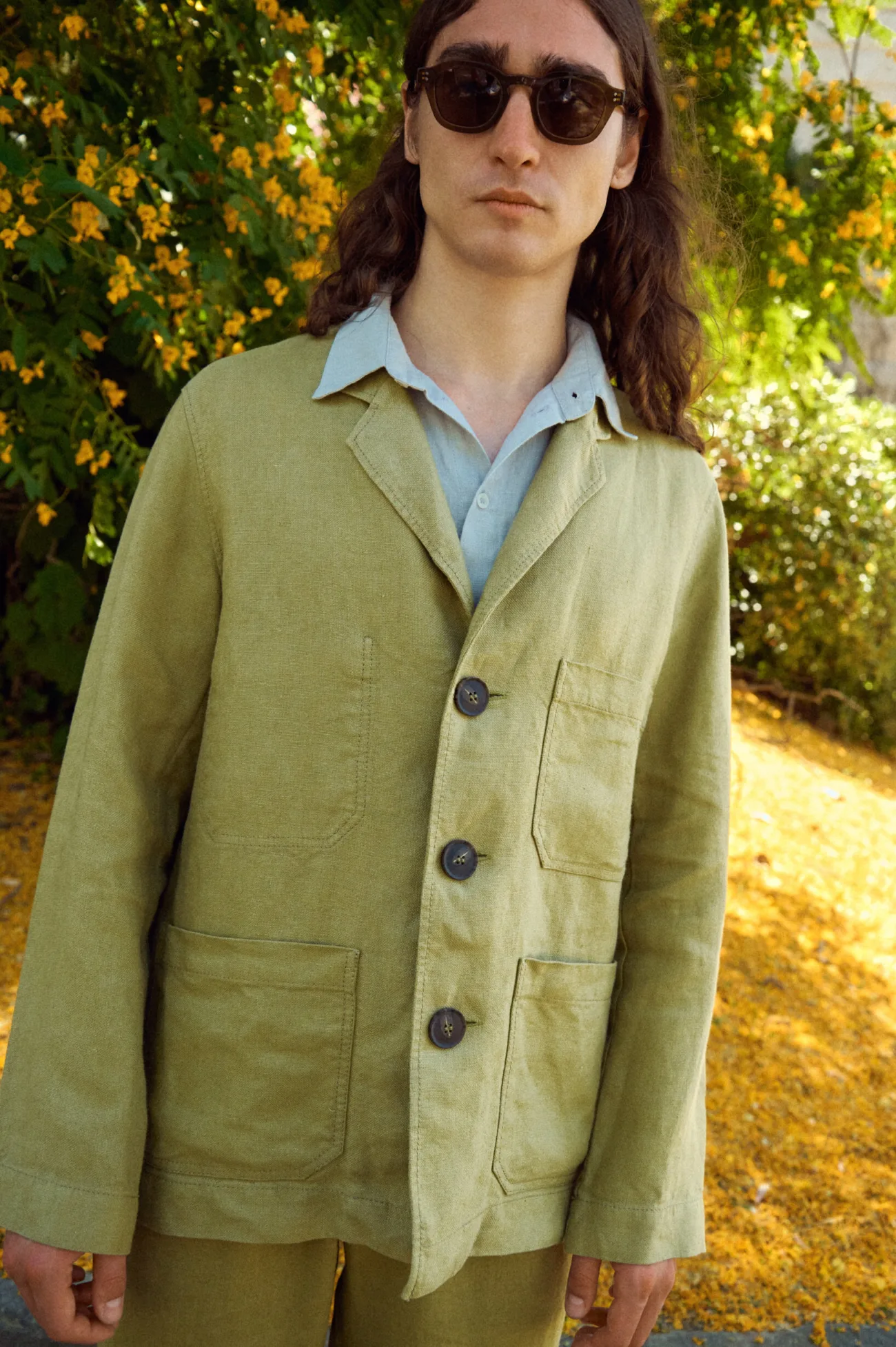 Men’s olive heavy linen jacket featuring a softly tailored shape, notched lapels, three dark statement buttons and a trio of practical patch pockets, layered with an ice grey linen shirt