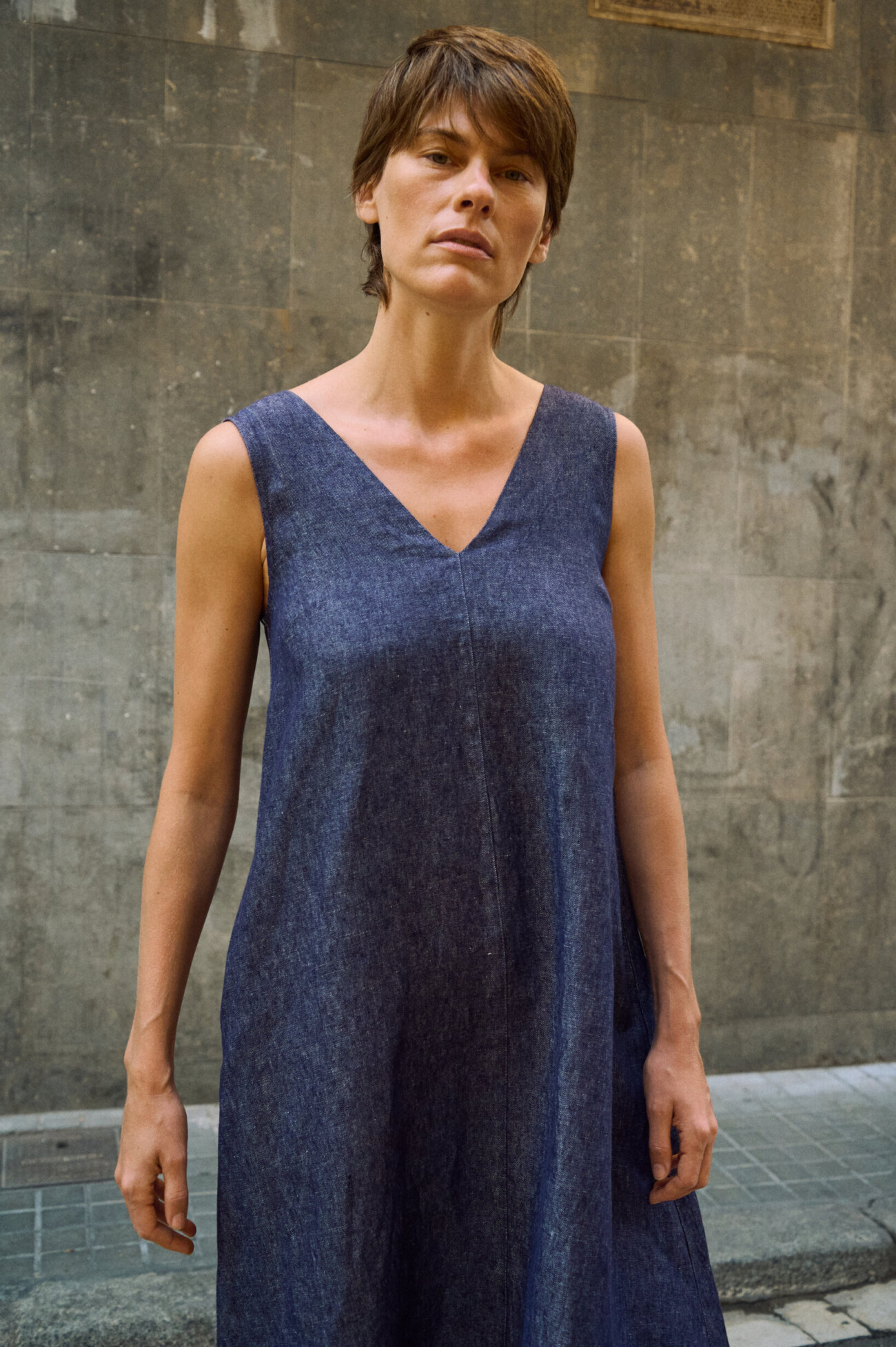 Close-up of blue denim linen sleeveless maxi dress highlighting the V-neck and center front seam