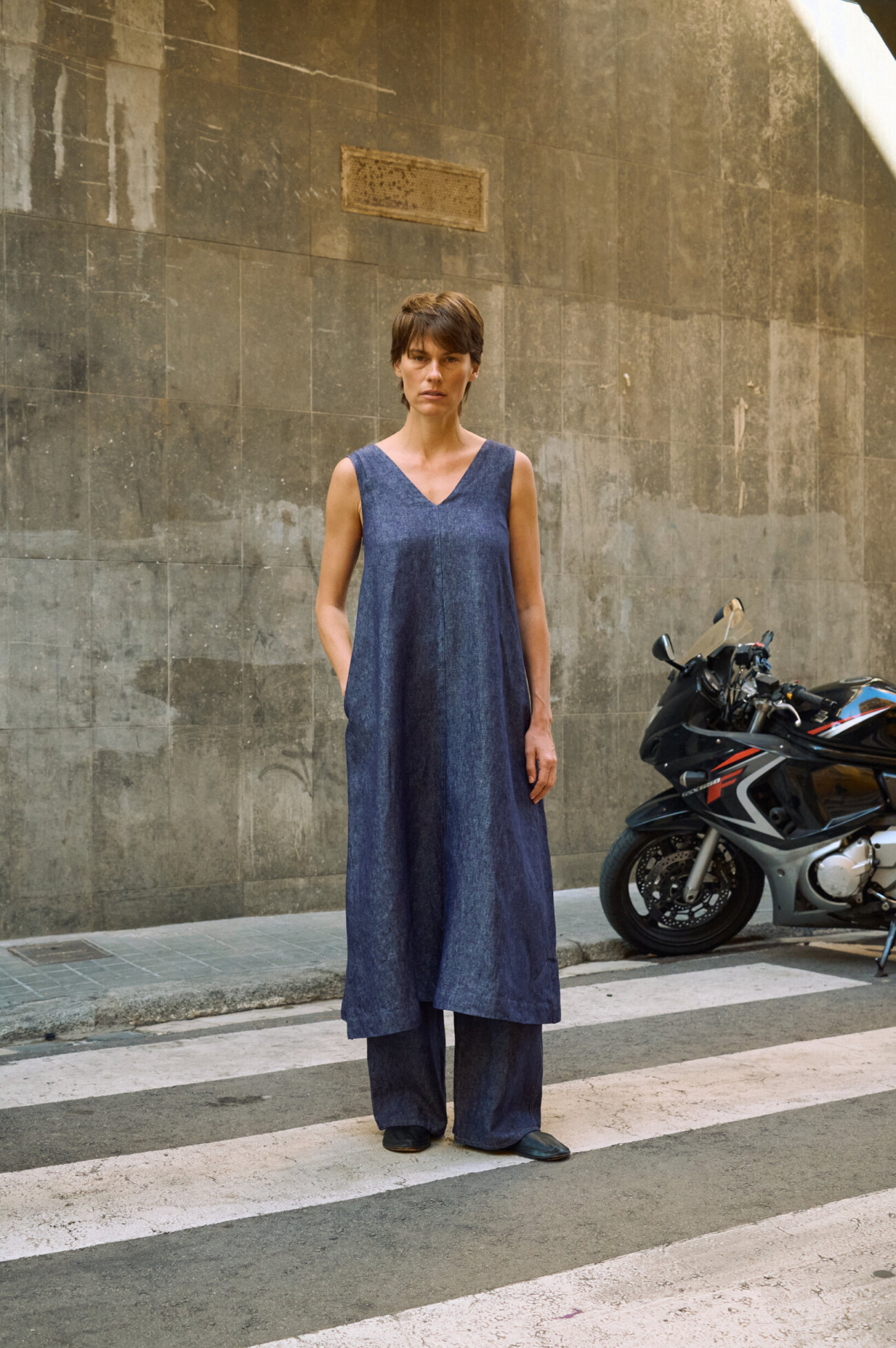 Blue denim linen sleeveless maxi dress with V-neck, side pockets, and relaxed A-line silhouette, layered over matching wide-leg denim linen pants