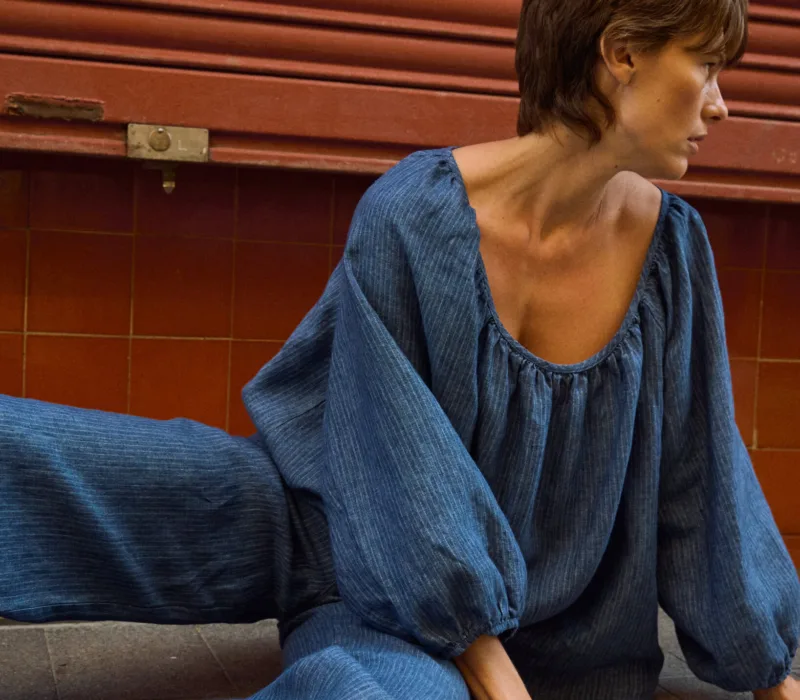 Blue striped linen blouse with a gathered scoop neckline and voluminous sleeves, paired with matching linen pants
