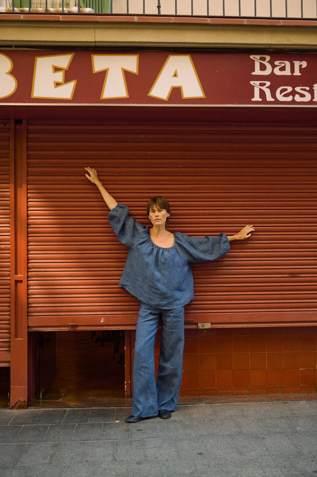 Blue striped linen wide-leg pants styled with a matching relaxed blouse with voluminous sleeves