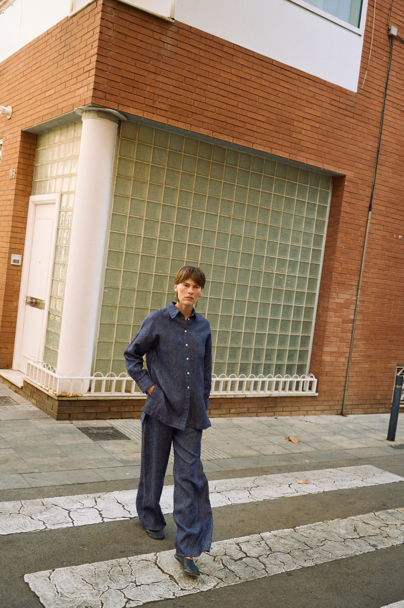 Blue denim linen pants with wide legs, styled with a matching button-down linen shirt while walking outdoors
