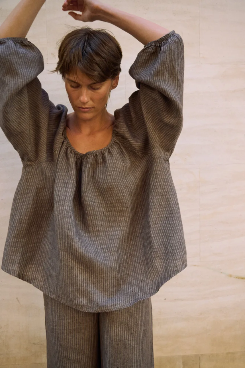 Close-up of a brown striped linen blouse with a softly gathered neckline and loose voluminous sleeves