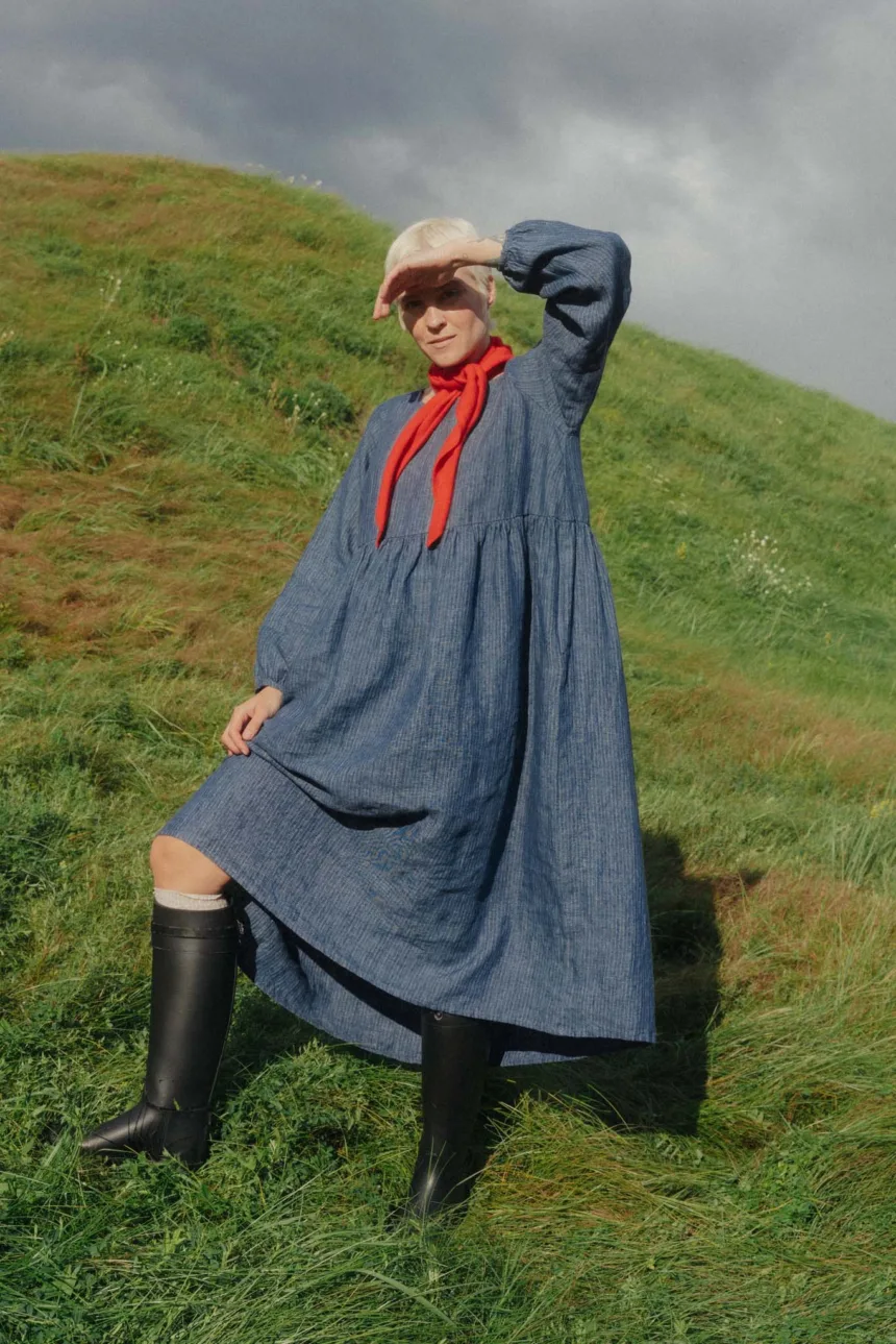 Flowing striped blue linen maxi dress featuring a gathered waist and softly voluminous long sleeves