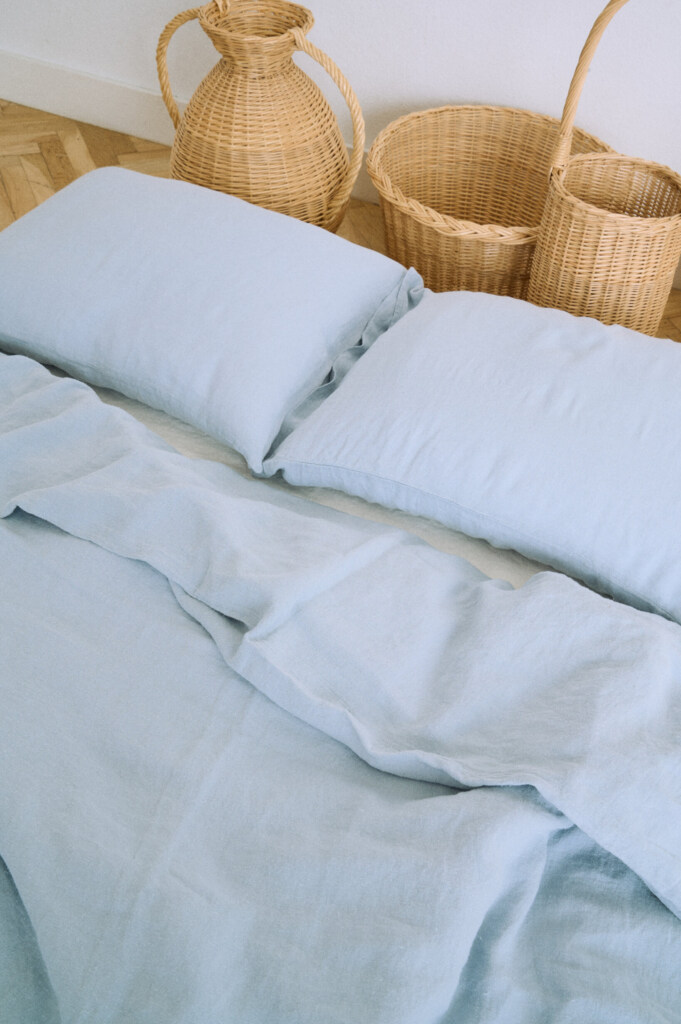 Blue linen pillowcase in dusty blue with envelope closure and washed finish.