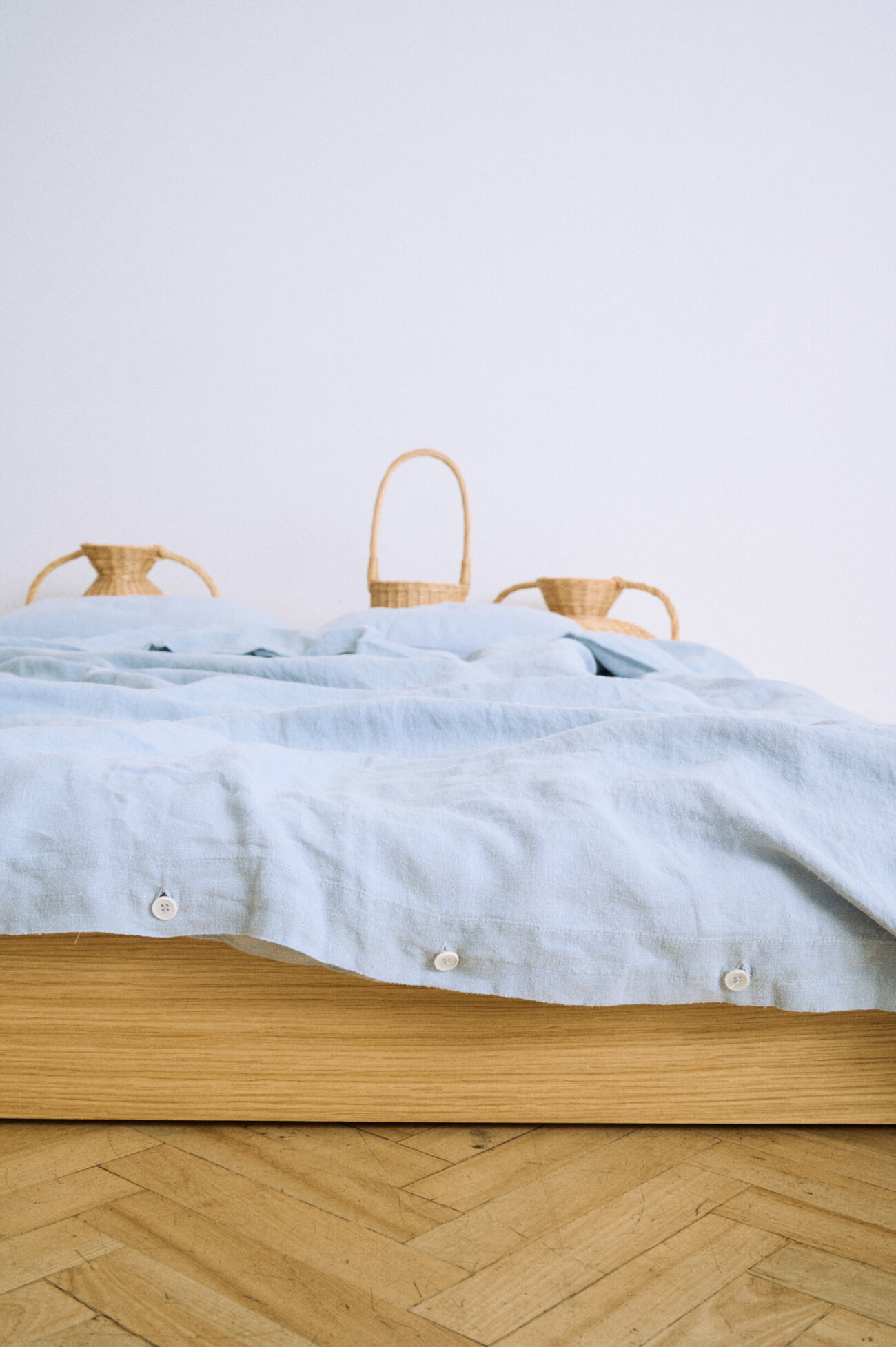 Detail of a blue linen duvet cover with white button closures