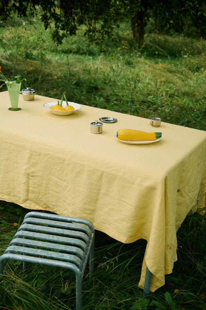 Butter yellow linen tablecloth covering a dining table.