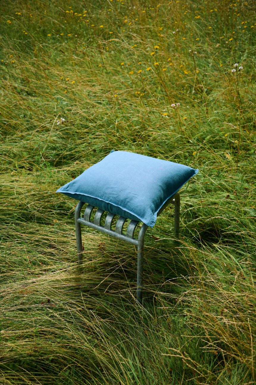 Stellar blue linen pillow cover with decorative stitched edges.