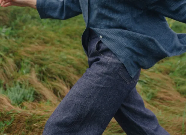 Relaxed blue pinstripe linen shirt with wide three-quarter sleeves, styled with dark blue denim linen trousers and a navy checked scarf